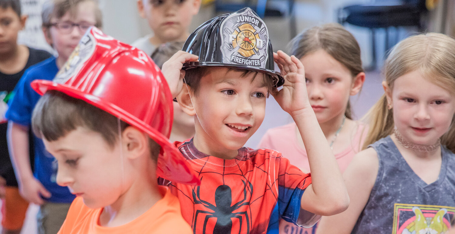 Kindergarten students receive firefighter hats during a visit to Lewis County Fire District 5 in Napavine on Tuesday, June 7.