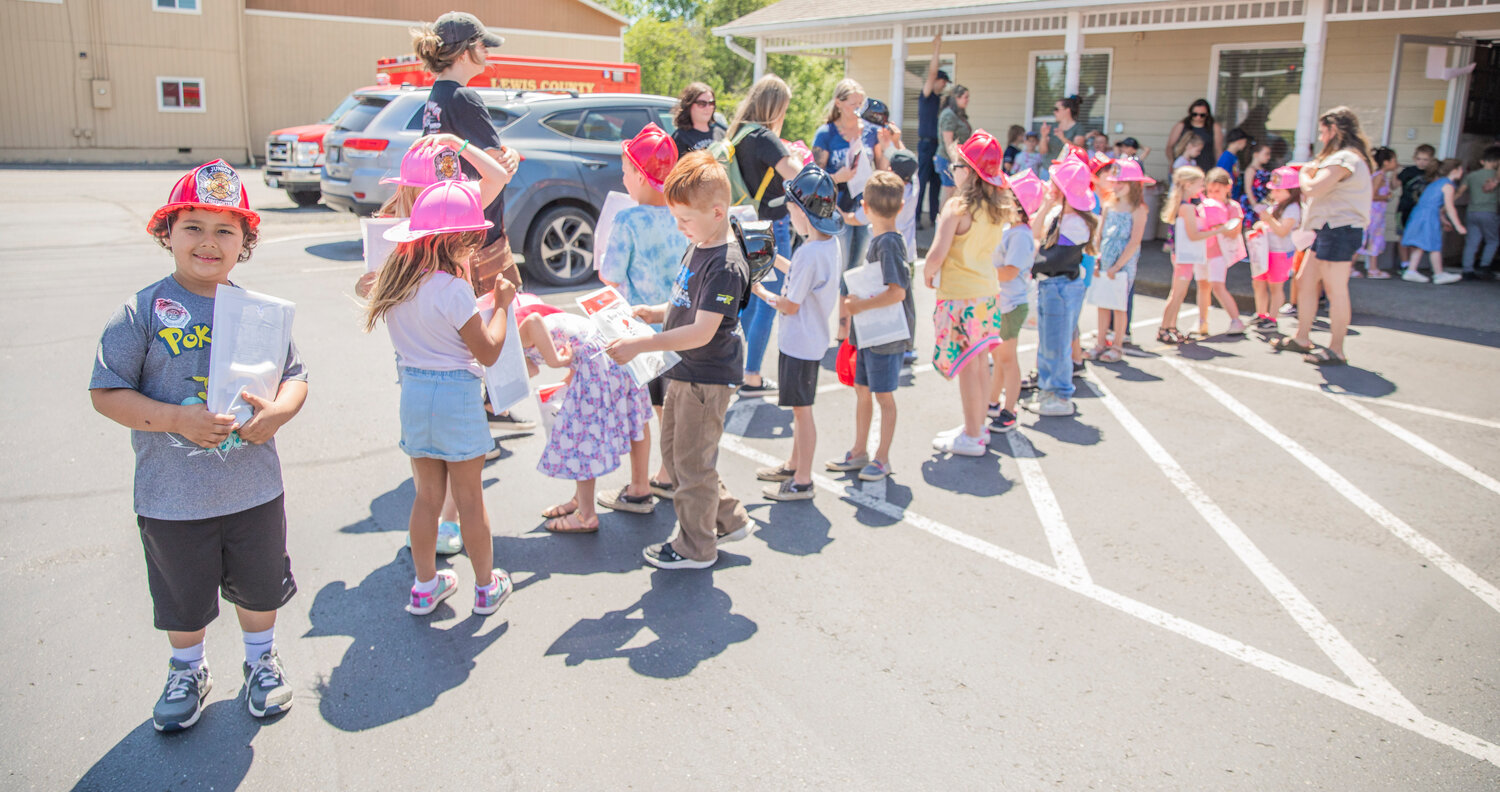 Kindergarten students receive firefighter hats and goody bags during a visit to Lewis County Fire District 5 in Napavine on Tuesday, June 7.