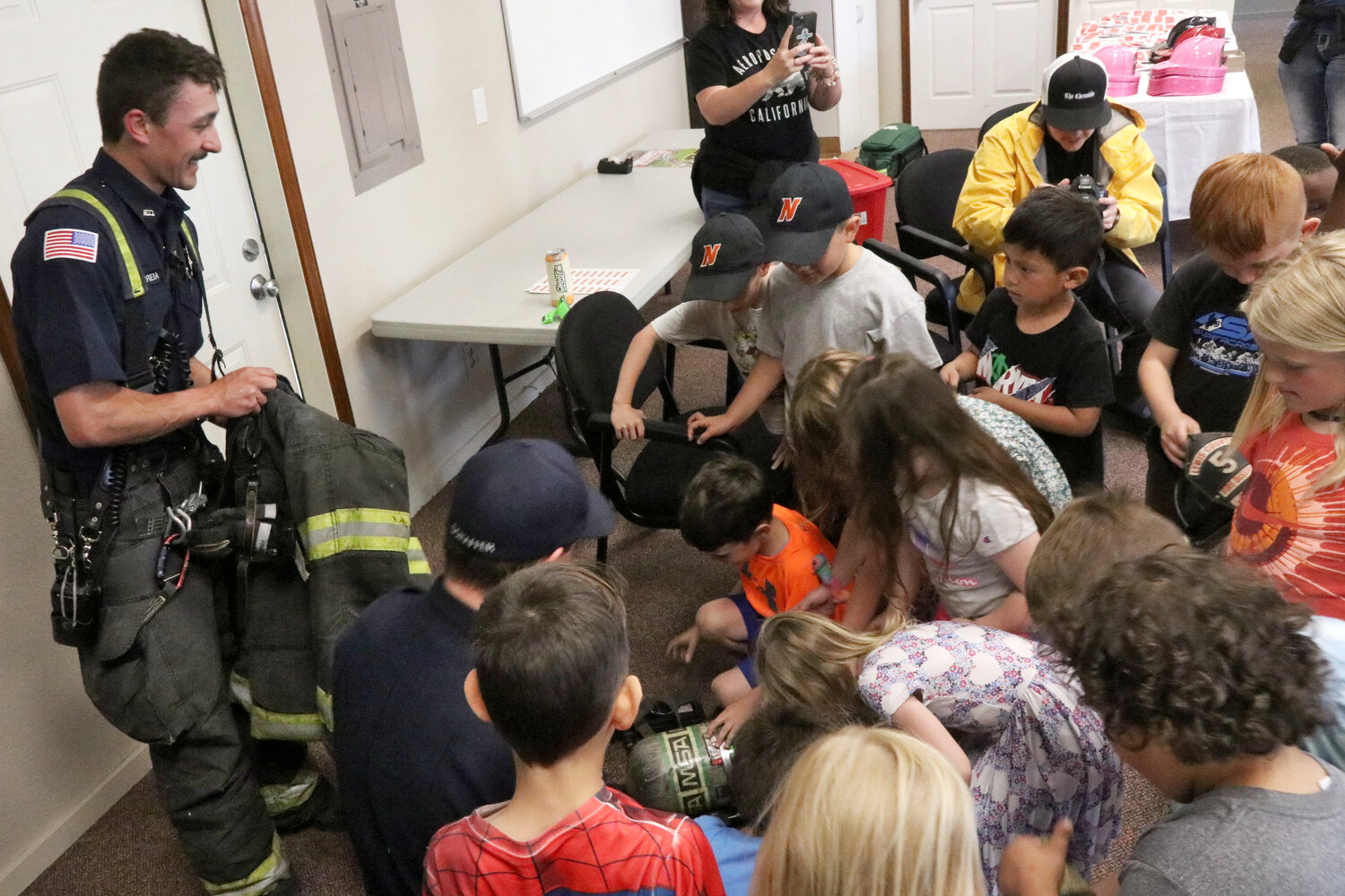 Kids crowd to get a closer look at a firefighter’s gear inside the Lewis County Fire District 5 station in Napavine on Tuesday, June 6.