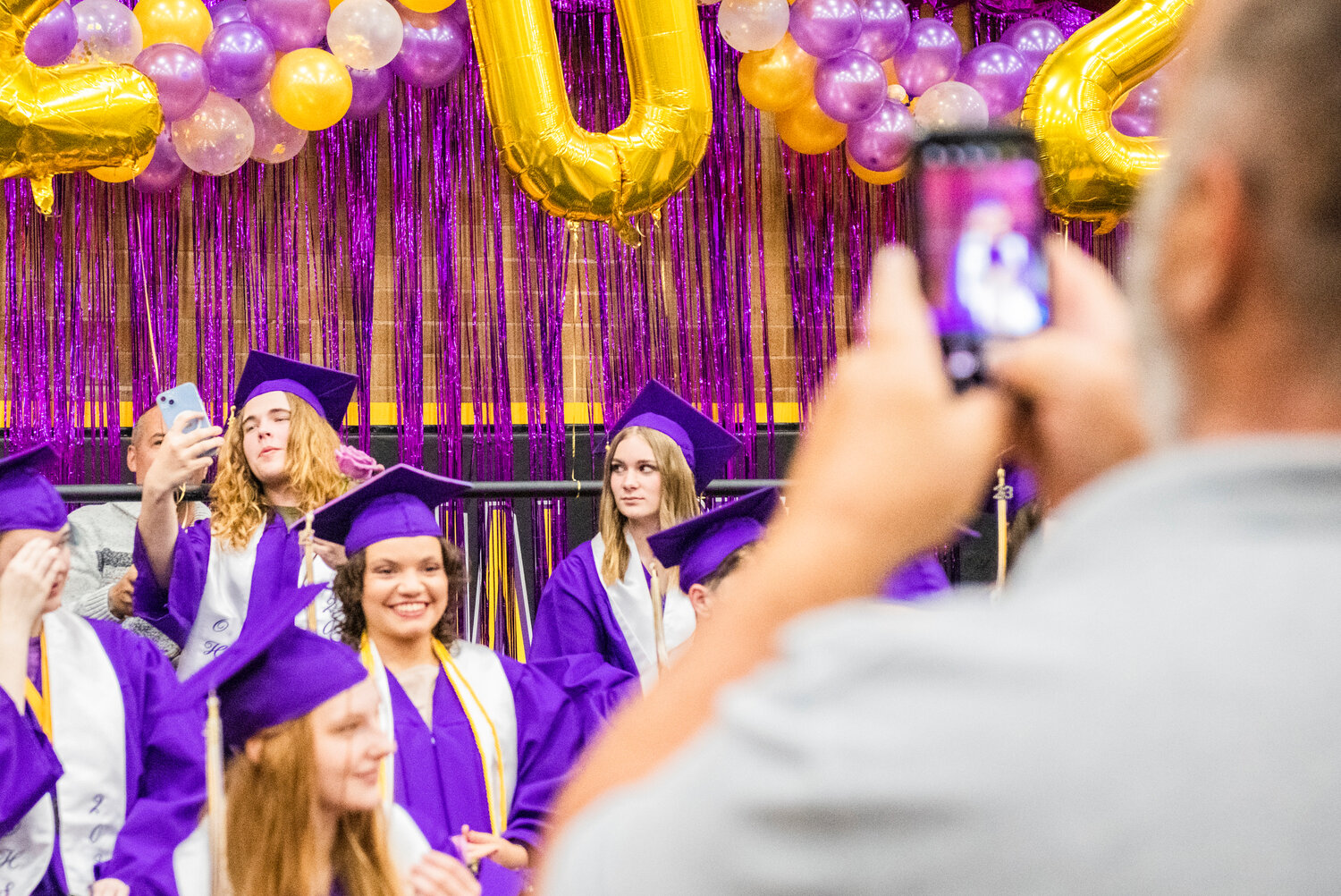 Onalaska High School students take selfies and pose for photos with family and friends at the start of their graduation ceremony on Friday night.