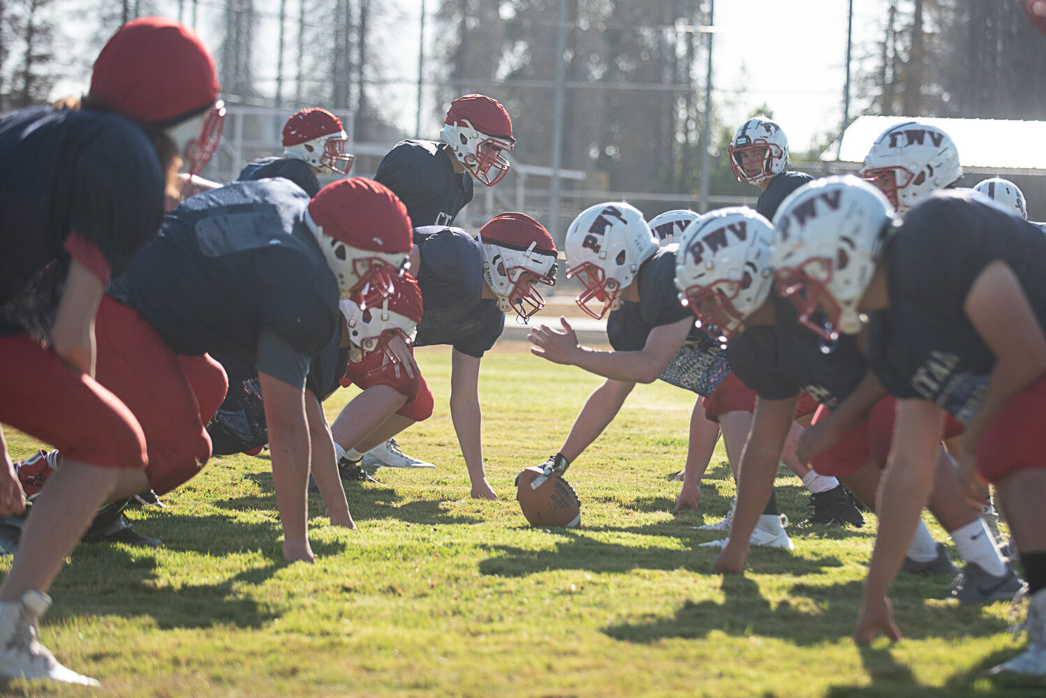 The offense and defense line up before a play during an 11-on-11 session of PWV's practice on Aug. 19, only differentiated by the red helmet caps worn by the defense.