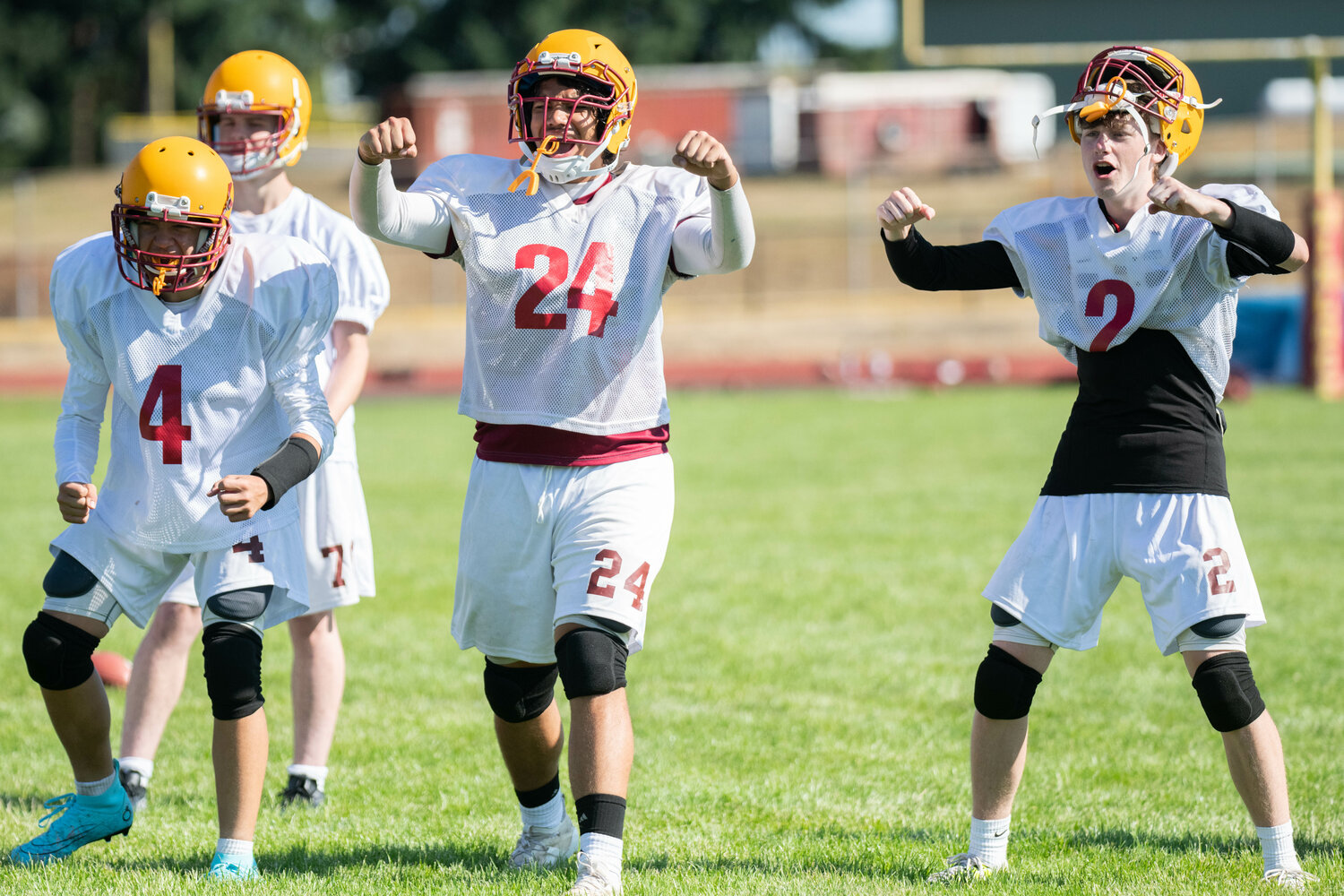 Landen Cline (4), Arean Thapa (24), and Carter Svenson (2) cheer on their teammates during a one-on-one blocking trill at Winlock's practice on Aug. 19
