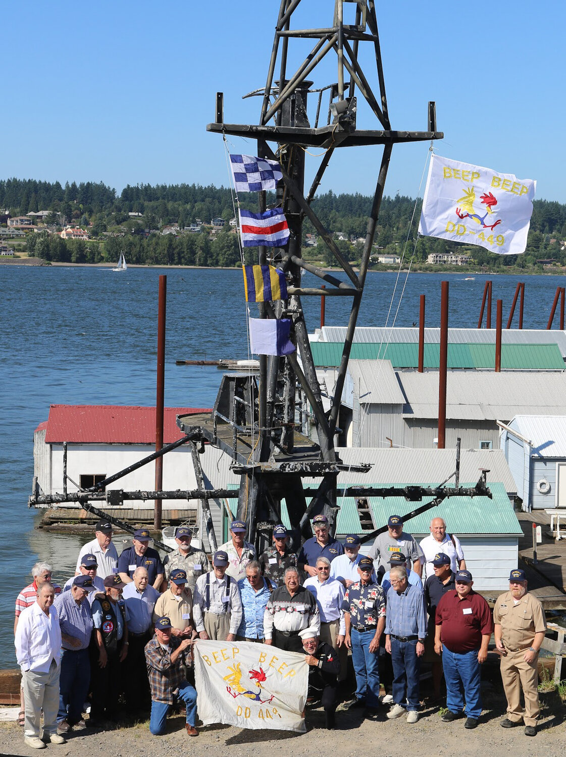 Members of the U.S.S. Nicholas Veterans Association pose with the ship's mast in Portland before disassembling it and moving it up to the Veterans Memorial Museum in Chehalis to be displayed. Photo courtesy John Bailey.