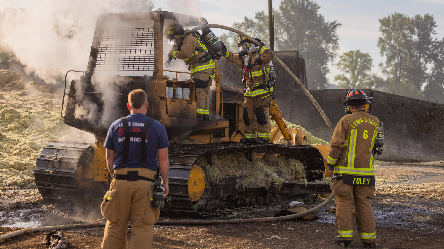 First responders from Lewis County Fire District 6 work to put out a fire inside a piece of machinery at the Osborne Dairy west of Chehalis on Sunday, Sept. 10. Smoke billowed above the area and could be seen from afar Sunday morning. There were no injuries.