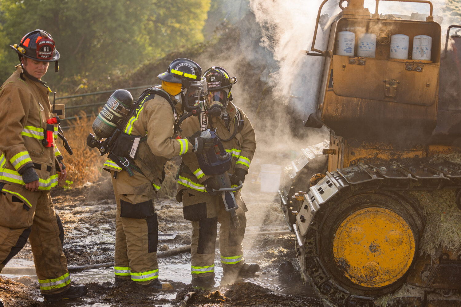 First responders from Lewis County Fire District 6 use jaws of life while working to put out a fire inside a piece of machinery at the Osborne Dairy west of Chehalis on Sunday, Sept. 10.