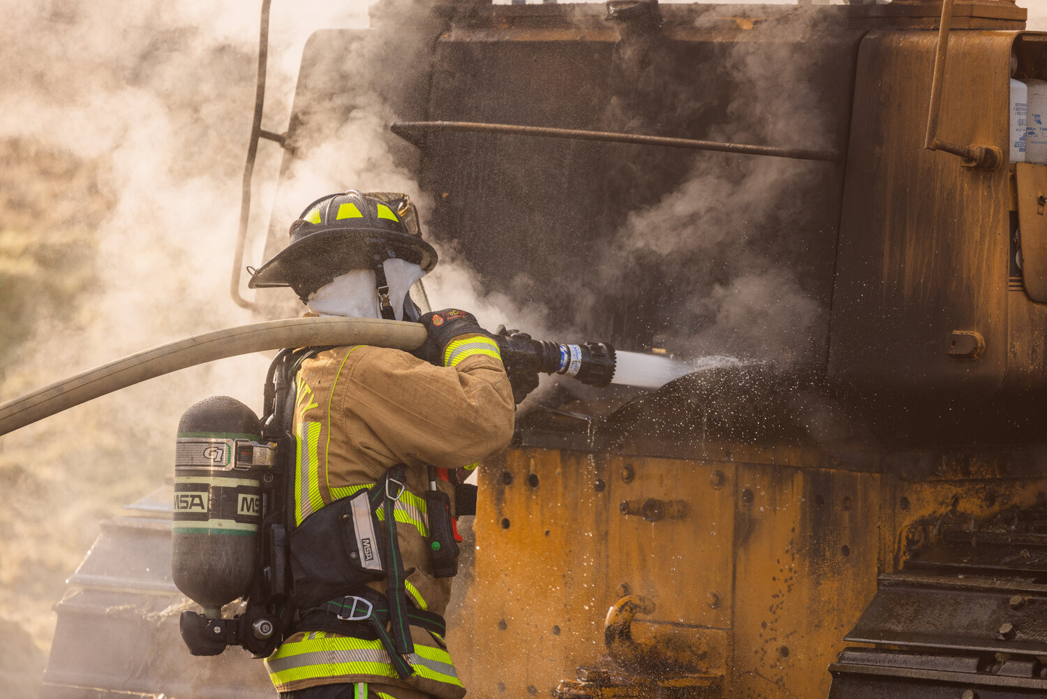First responders from Lewis County Fire District 6 work to put out a fire inside a piece of machinery at the Osborne Dairy west of Chehalis on Sunday, Sept. 10.