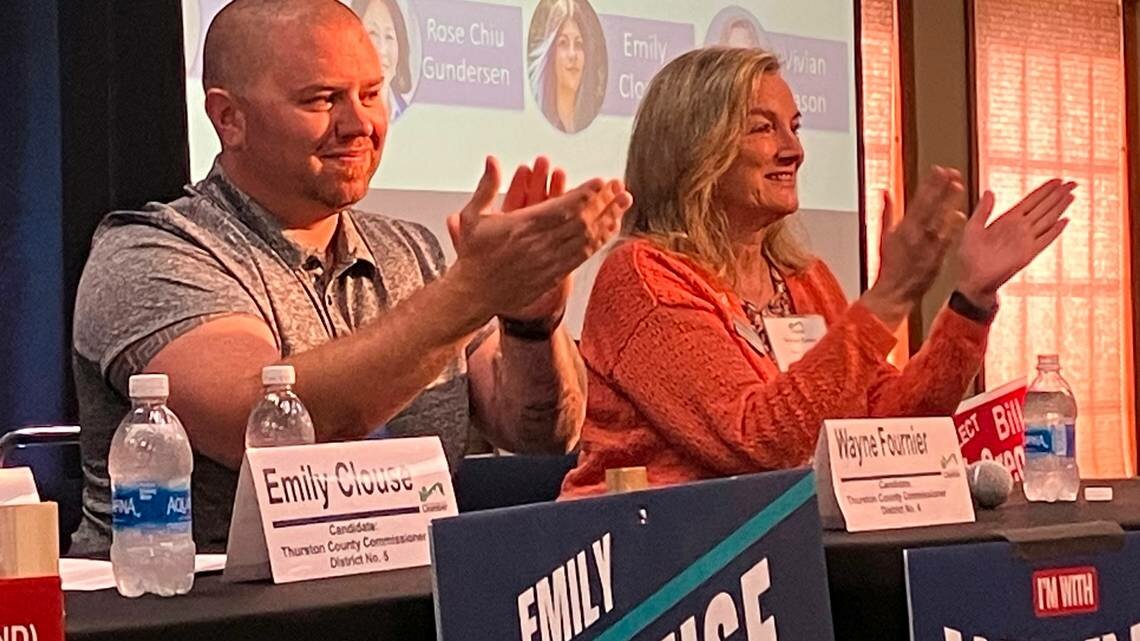 Thurston County District 4 commission candidates Wayne Fournier and Vivian Eason applaud in response to audience members applauding for them at a Wednesday candidate forum.