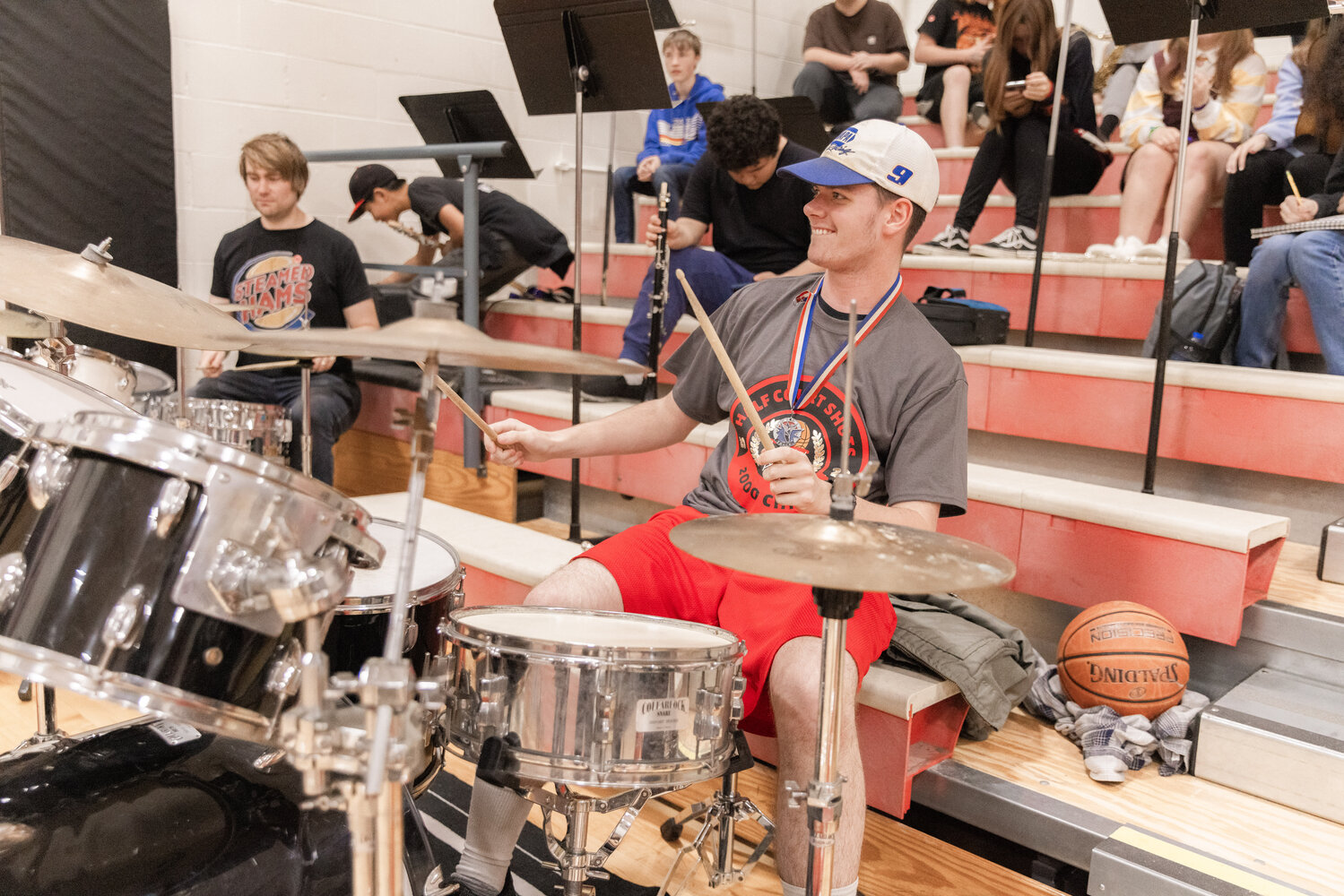 Chris Harvey smiles and beats on the drums after sinking a shot to mark 2,000 made half-court buckets at Toledo High School on Thursday, Sept. 21.