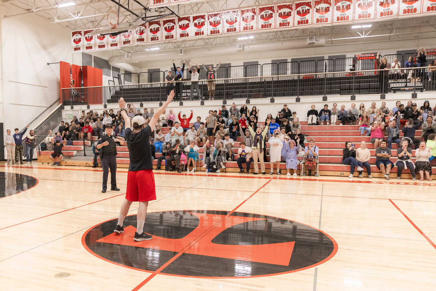 Chris Harvey celebrates 2,000 made half-court buckets as a crowd erupts at Toledo High School on Thursday, Sept. 21.