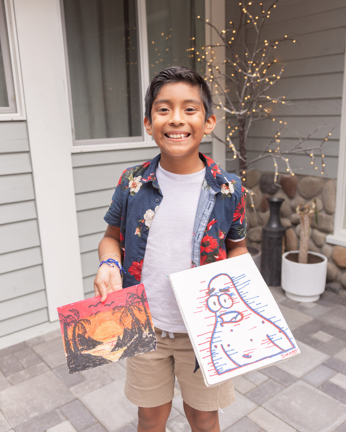 Isaac Flores smiles and holds up drawings he made at his Centralia residence on Tuesday, Sept. 19.