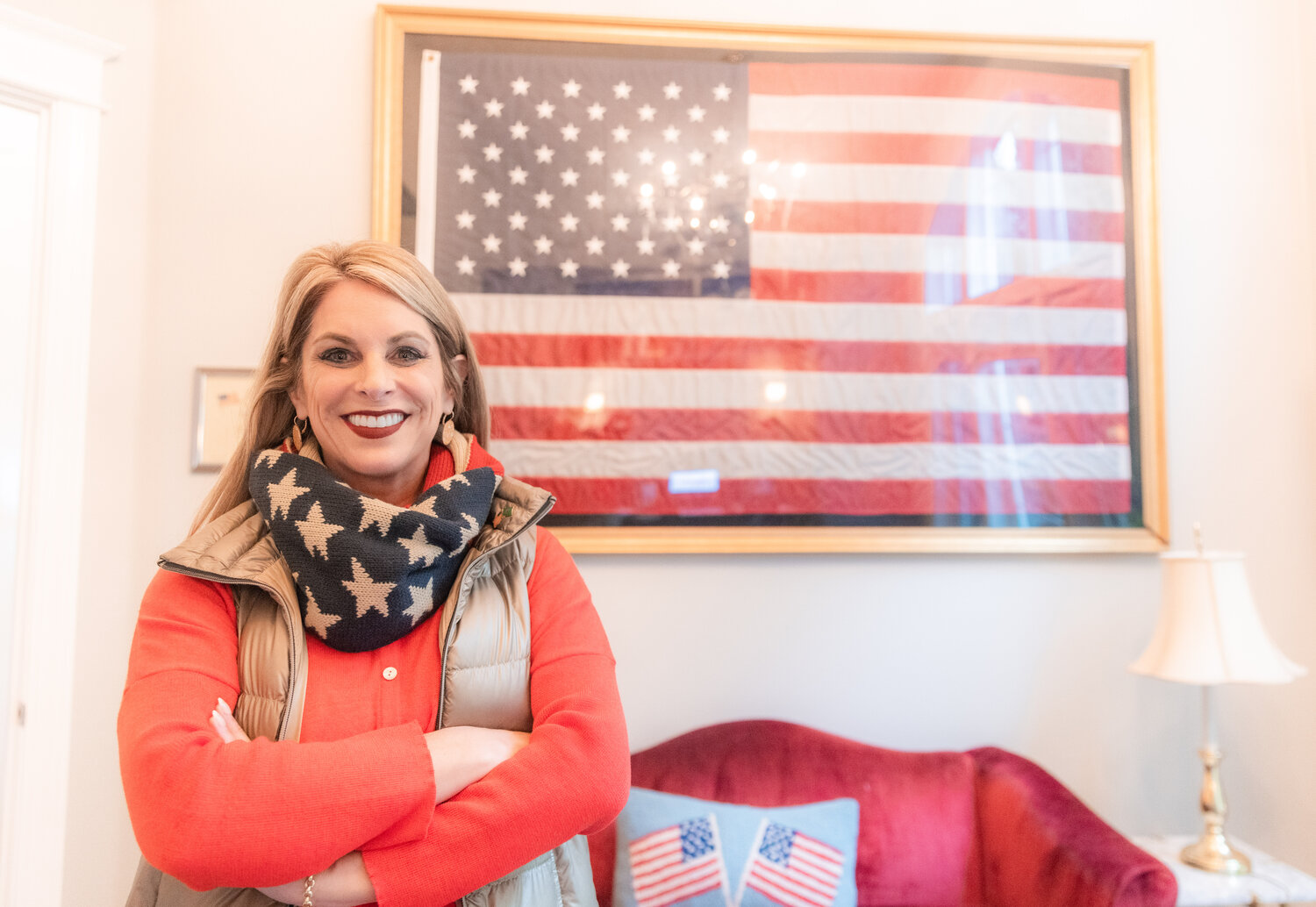 Leslie Lewallen smiles for a photo in front of a flag that once flew over the White House Tuesday morning at her Camas home.
