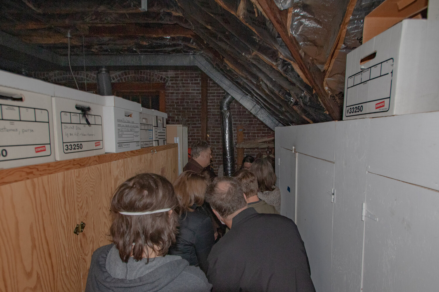Ghost tour attendees gather in the attic of the Lewis County Historical Museum on Saturday, Oct. 28, to listen to electronic voice phenomenon captured on audio recorders by paranormal investigators at the museum in the past.