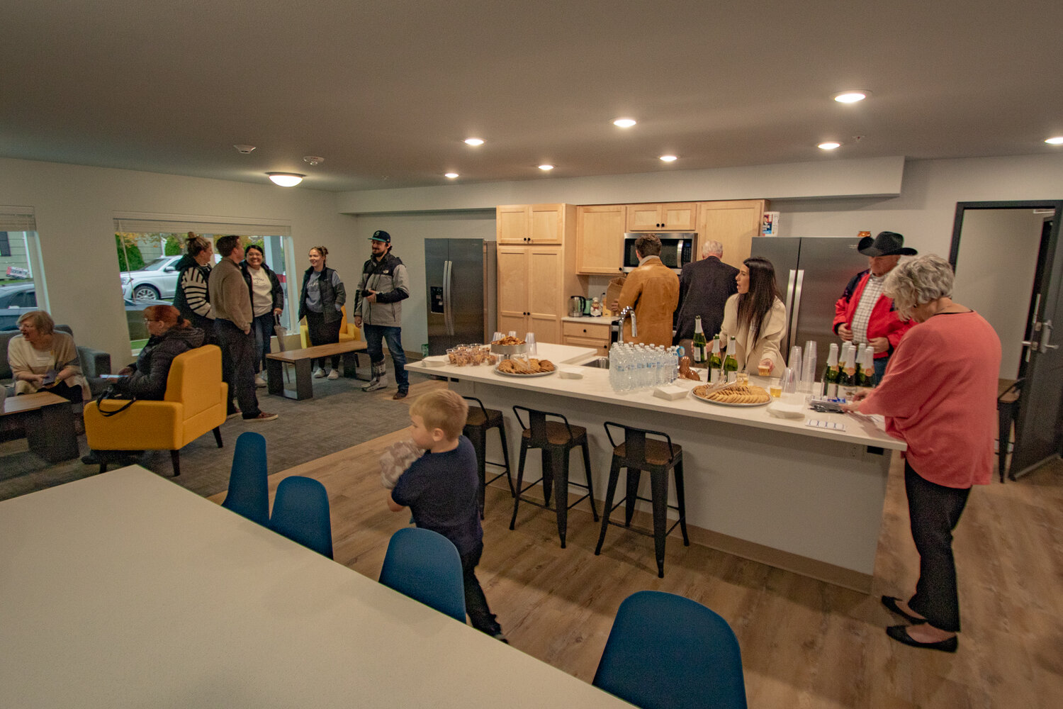 Guests gather in an apartment common area and kitchen for an open house celebrating the completion of the new CHI apartments, located at 111 S. Ash Street, on Tuesday, Nov. 7.