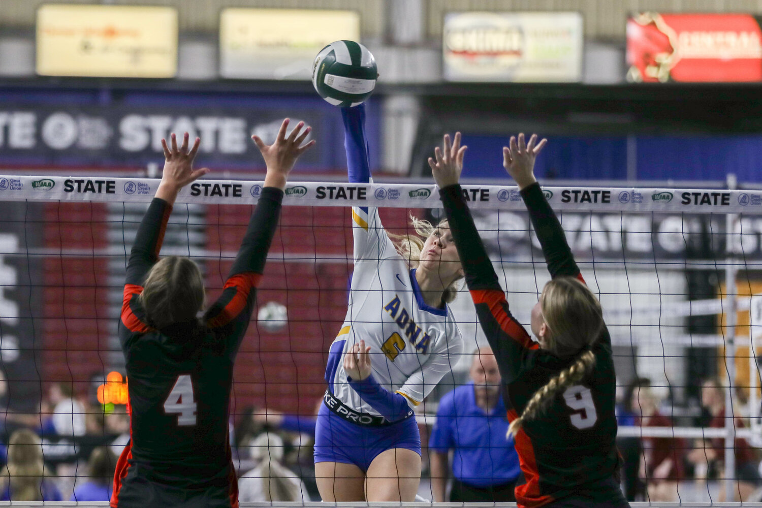 Karsyn Freeman spikes the ball between two defenders during Adna's win over Liberty at the state tournament on Nov. 9 in Yakima.