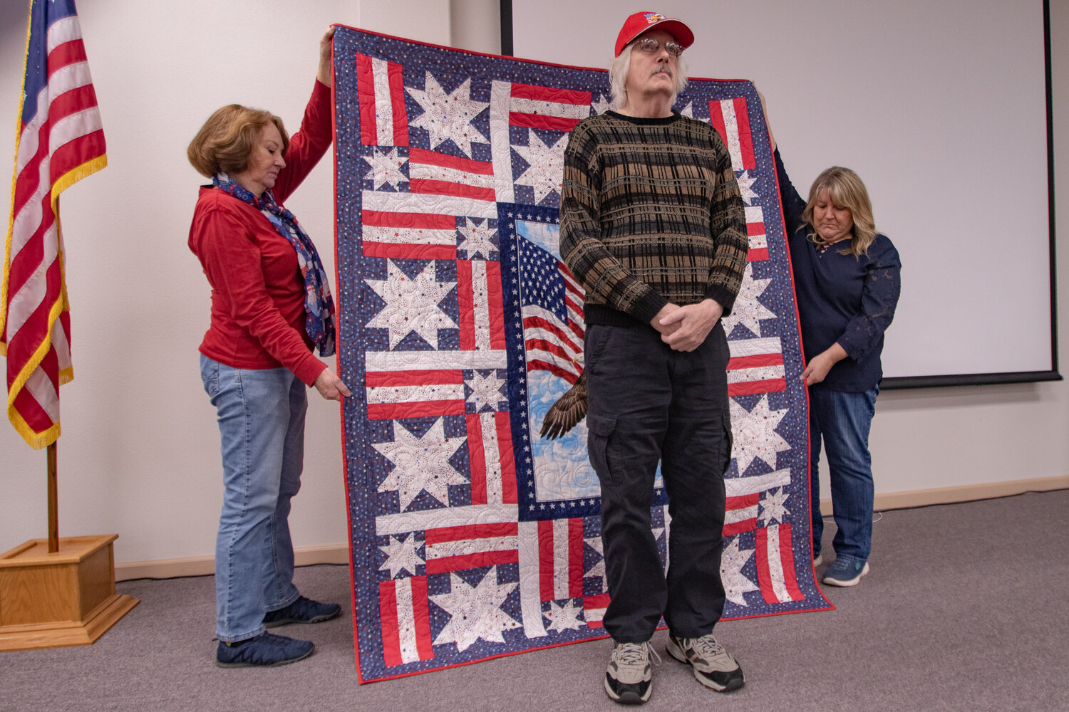 U.S. Army veteran Carl Stone stands in front of his quilt presented to him on Saturday, Nov. 11, by the Veterans Memorial Museum Quilts of Valor chapter.
