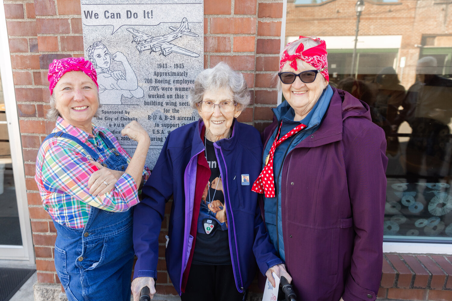 Marie Panesko, Doris Bier and Edna Fund smile for a photo on Thursday in front of a “Rosie The Riveter” plaque honoring Boeing employees who crafted wing sections for the B-17 and B-29 aircraft during World War II. The plaque is on display in Chehalis outside the Lewis County Public Utility District building.