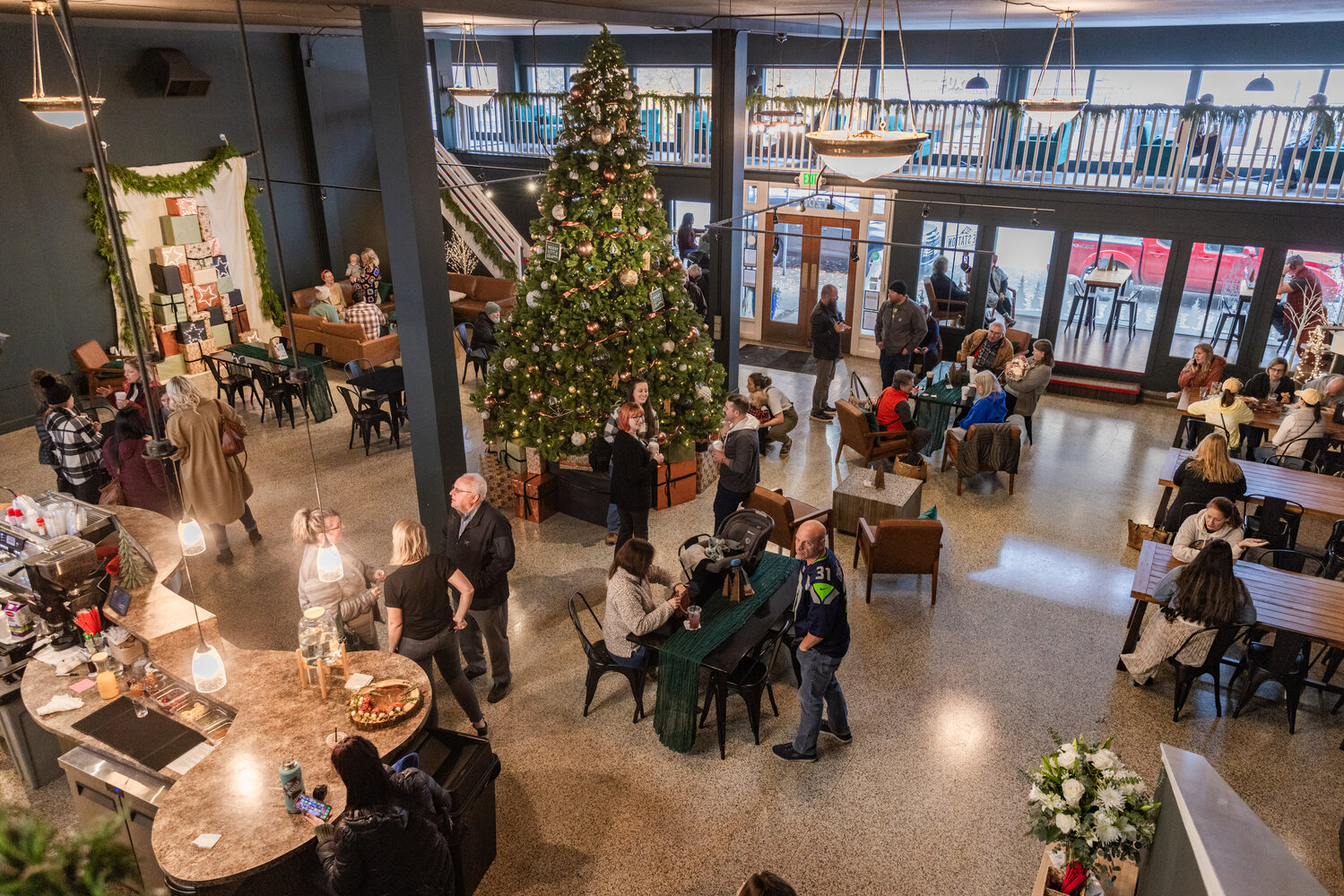 Visitors mingle around a Christmas tree inside The Station powered by Lewis County Coffee Company in downtown Centralia on Friday, Nov. 17. After a week of renovations, the downtown Centralia business held a grand re-opening to showcase its fresh look on Friday.