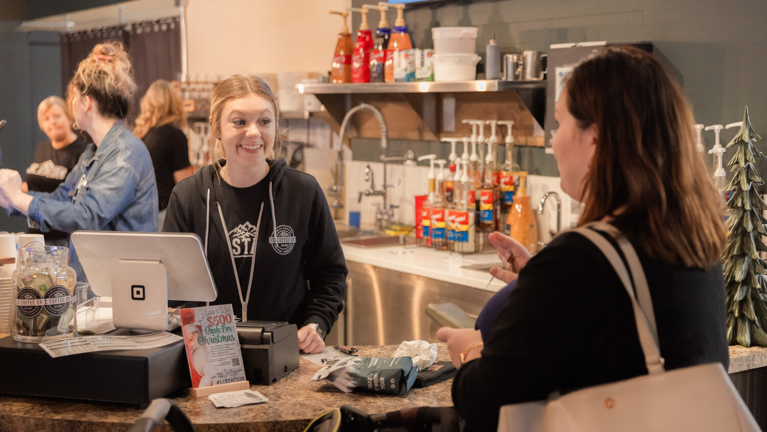 Employees smile as visitors order inside The Station powered by Lewis County Coffee Company in downtown Centralia on Friday, Nov. 17.