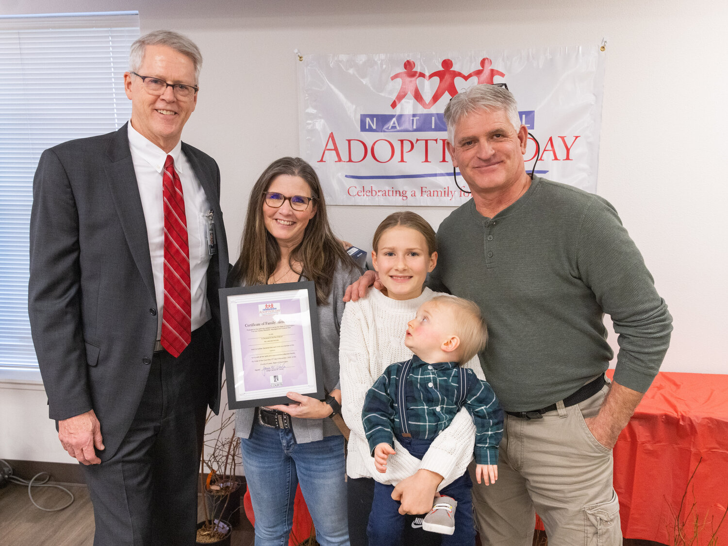Rachel and William Harris pose for a photo with Judge James W. Lawler and their kids on National Adoption Day Friday afternoon in Chehalis.