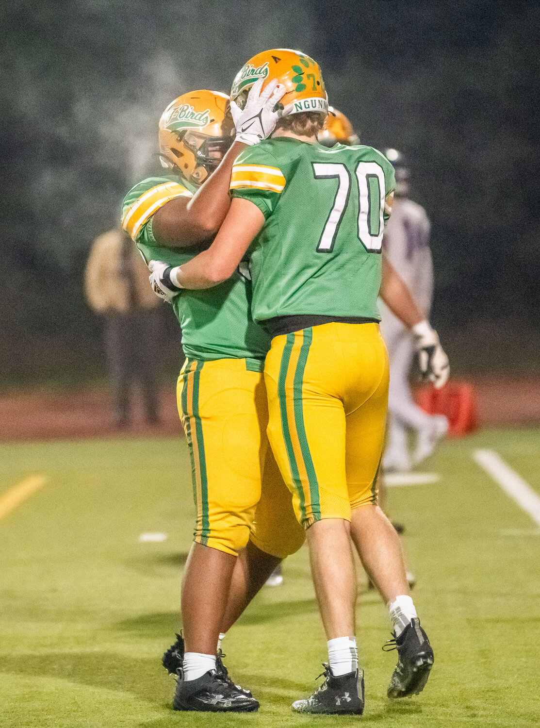 Tumwater’s Malijah Tucker hugs Nathan Boone (70) after a defensive play during a 2A state semifinal game on Saturday.