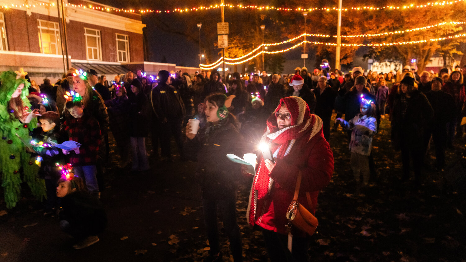 Crowds sing Christmas carols while waiting for Santa to arrive at George Washington Park in Centralia during a tree lighting ceremony on Friday, Nov. 24.