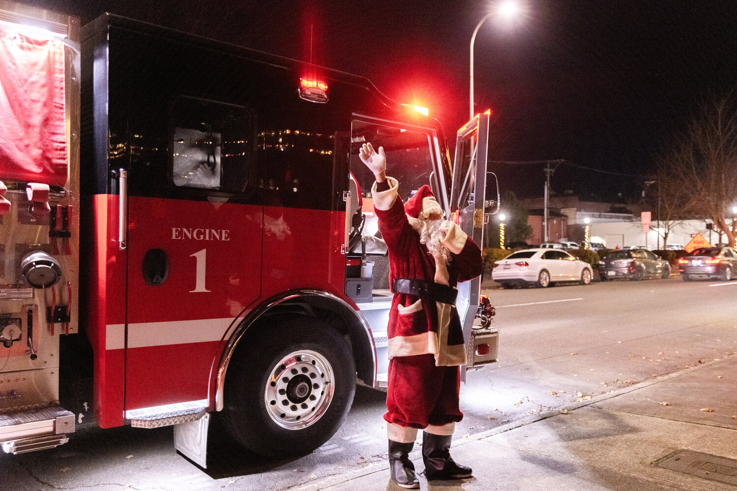 Santa steps out of Riverside Fire Authority Engine 1 waving to visitors at George Washington Park in Centralia during a tree lighting ceremony on Friday, Nov. 24.