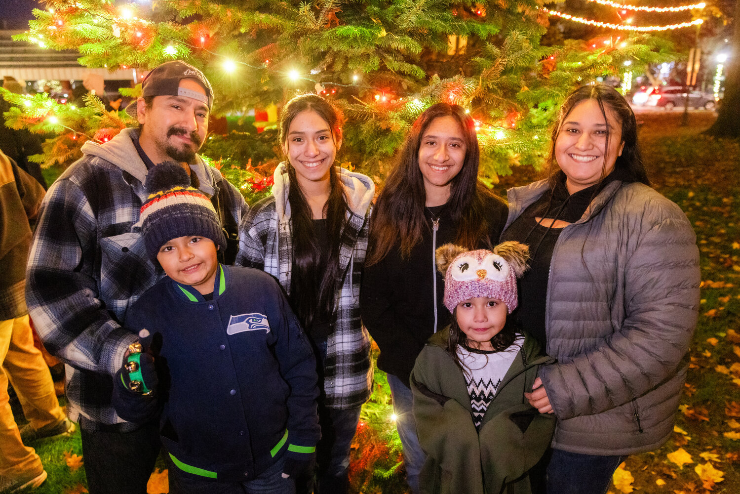 The Vasquez family smiles for a photo in front of a lit Christmas tree at George Washington Park in Centralia on Friday, Nov. 24.