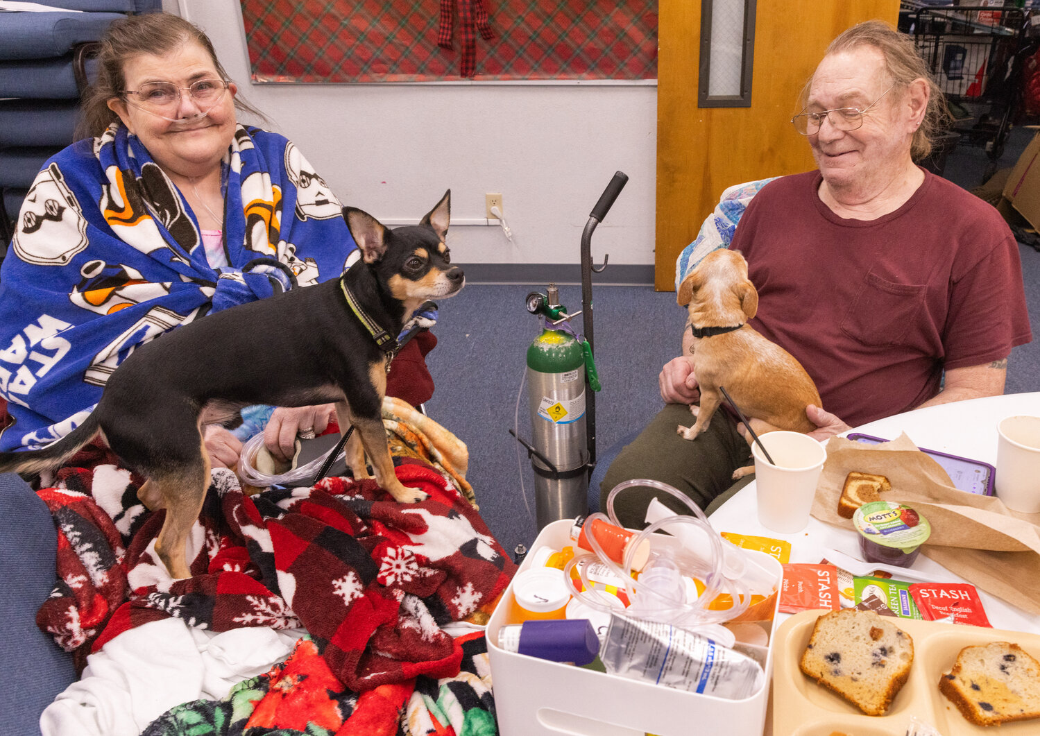 Donna Burgie, 64, and her husband Charles, 73, smile as Nico and Zeus, their Chihuahuas, sit on their laps after they were evacuated from their residence at the Centralia Manor Apartments following a fire on Wednesday, Nov. 29.