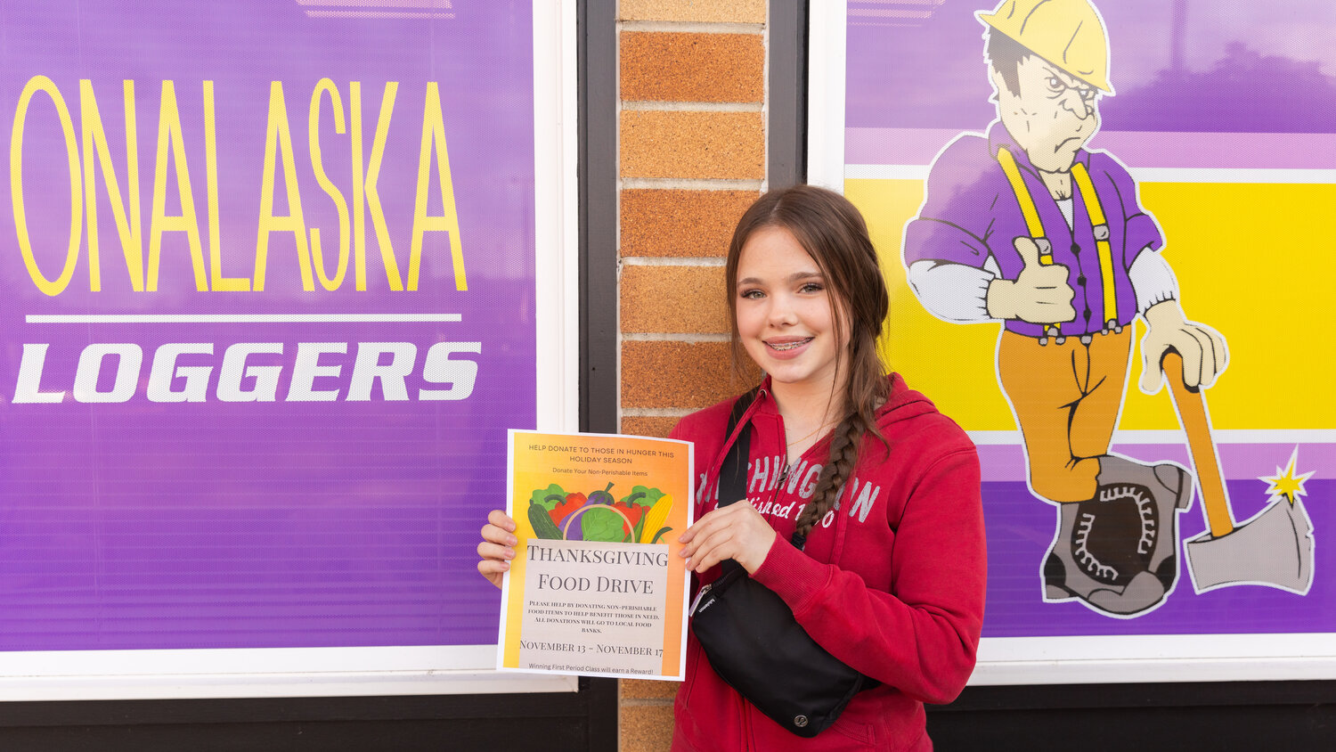 Kate Zandell smiles for a photo on Tuesday, Nov. 28, while holding up a Thanksgiving Food Drive flier she designed at Onalaska High School to help raise awareness around hunger during the holiday season.