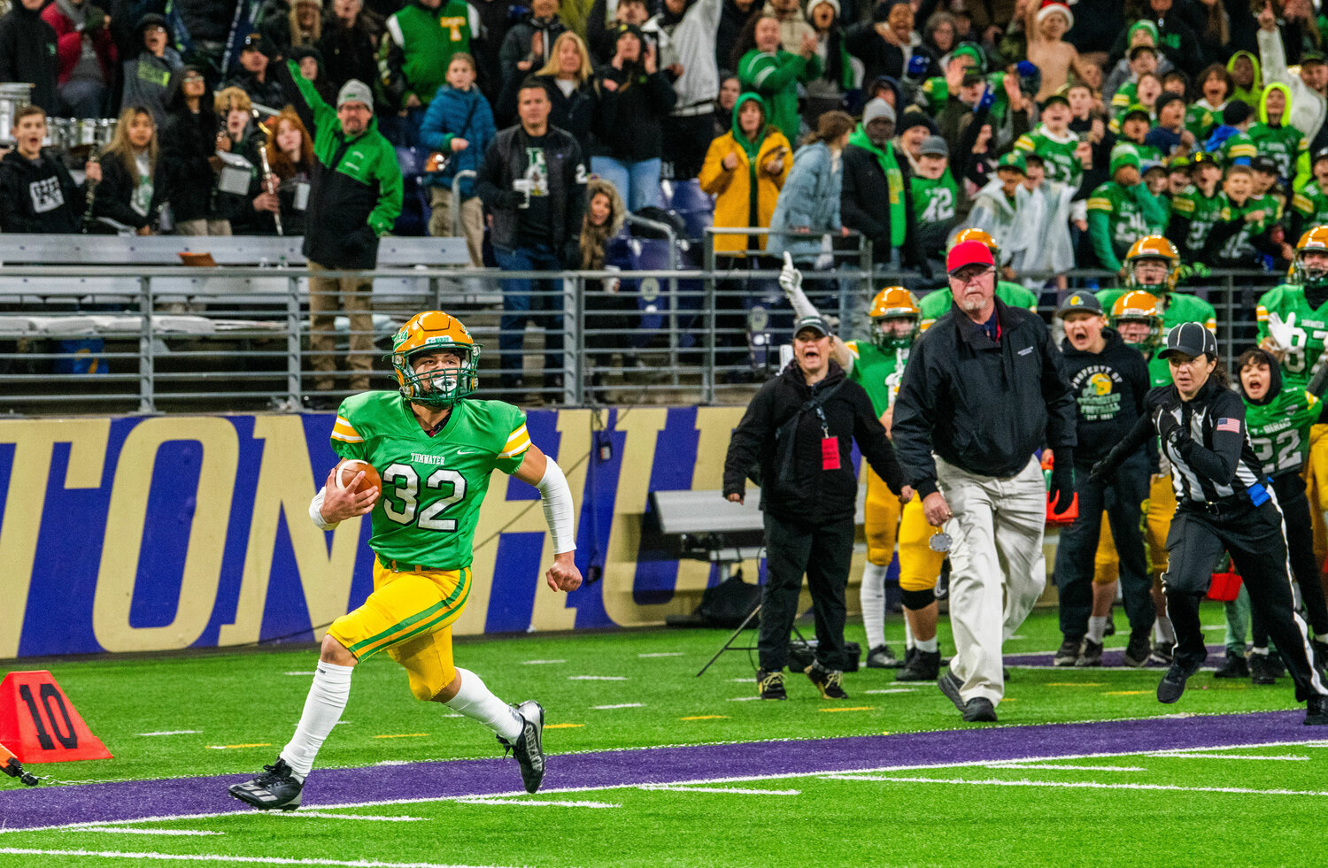 Tumwater’s Peyton Davis (32) completes a long fourth-down conversion running through Anacortes defenders during the 2A State Championship on Saturday.