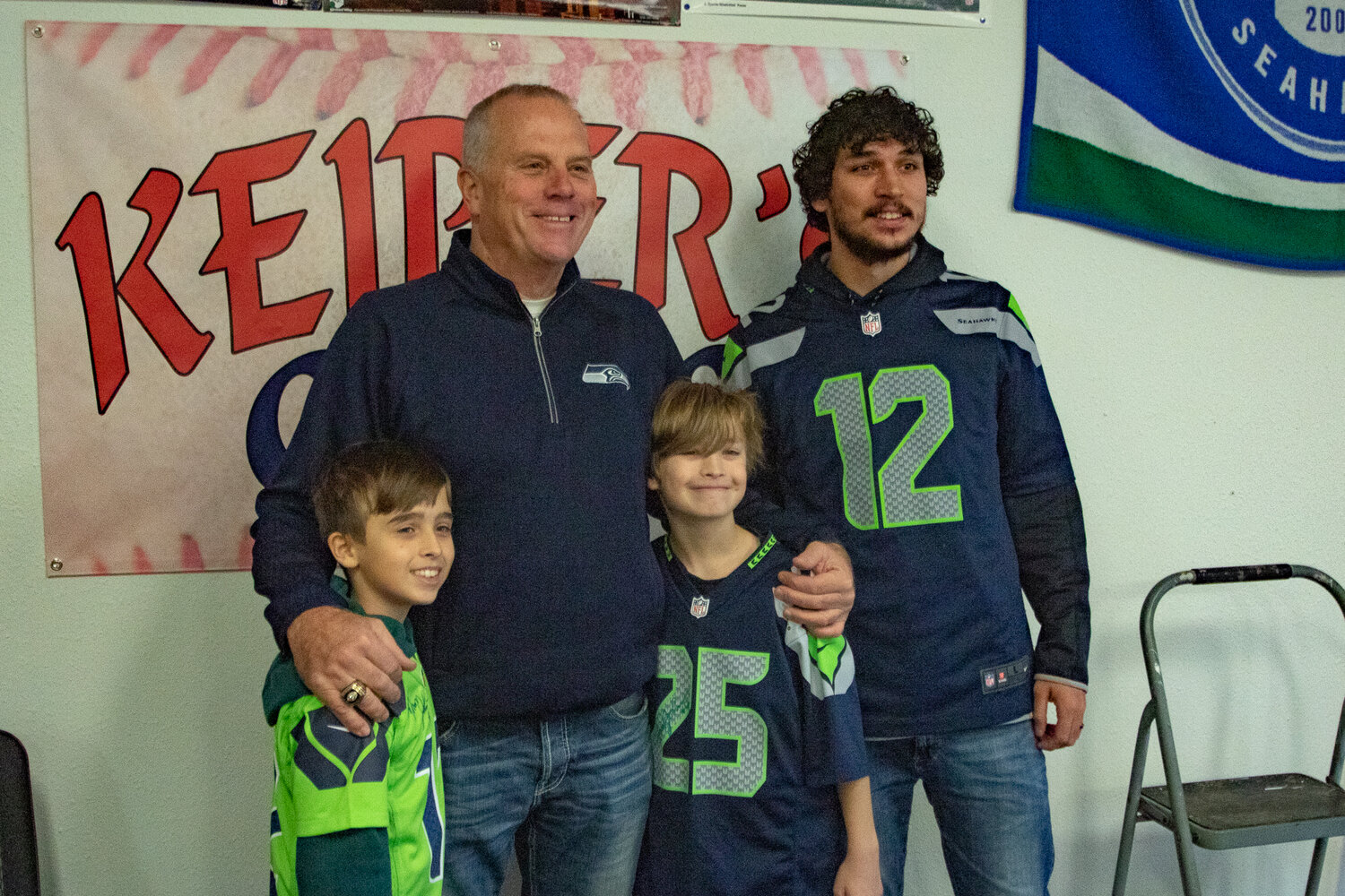 Former Seattle Seahawks kicker Norm Johnson, also known as "Mr. Automatic," poses with Cohen, in the green, and Bernard Collette along with their father, Tom Collette, at Keiper's Cards on Saturday, Dec. 2. during a card and memorabilia show in downtown Centralia.