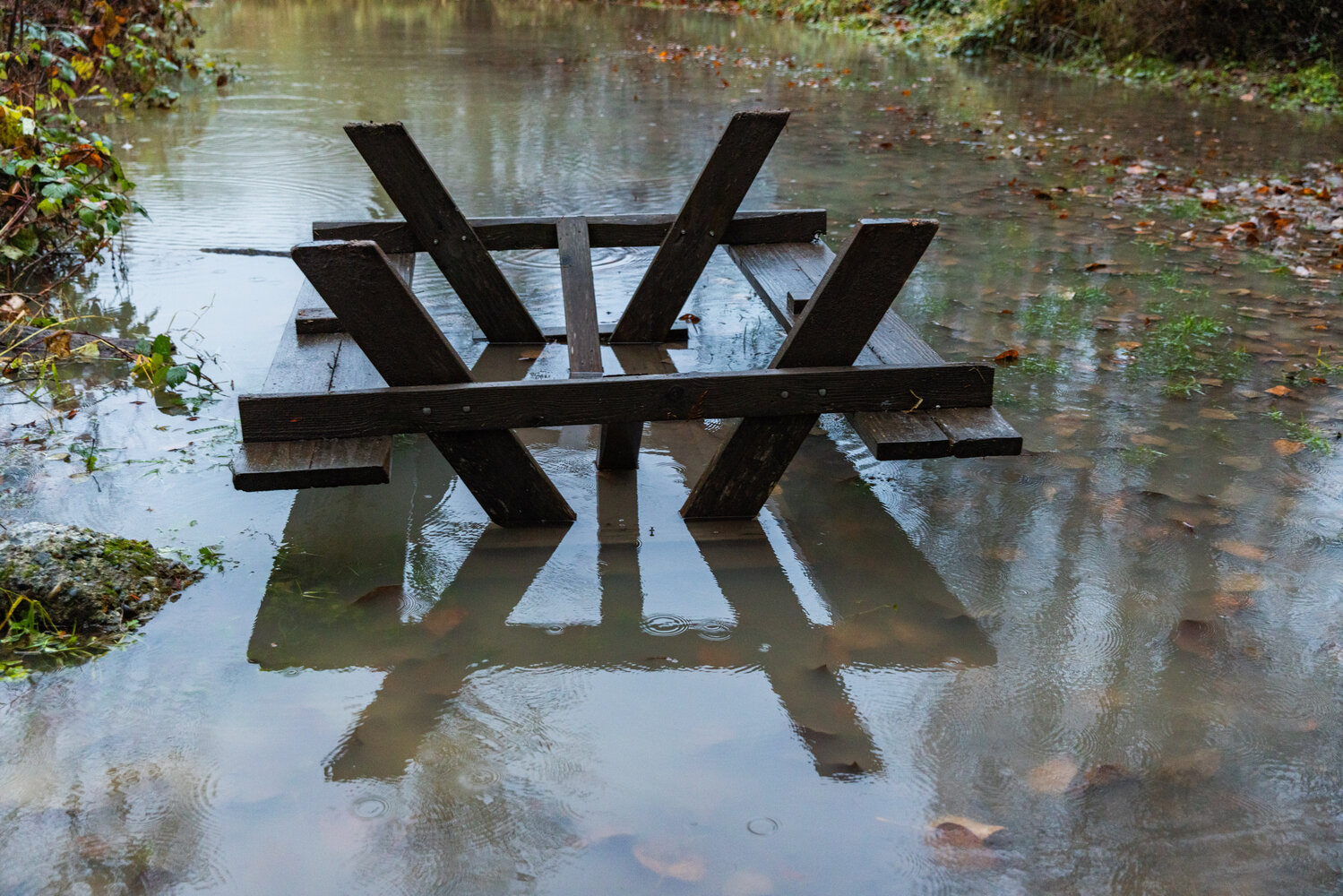 An overturned picnic table sits in water from the Cowlitz River inside the Cascade Peaks Resort and Campground in Randle on Wednesday, Dec. 6.
