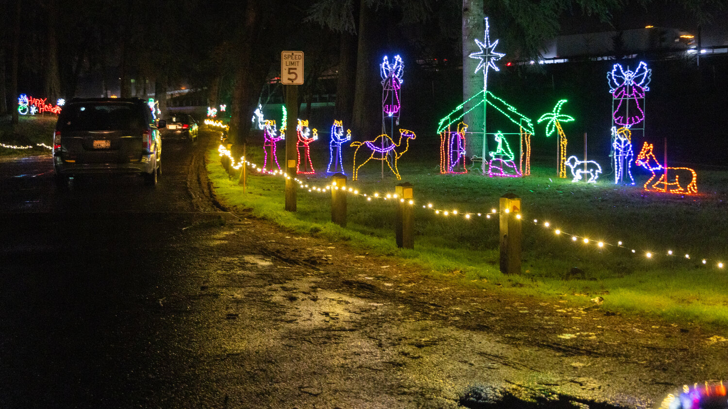 Vehicles drive past a manger scene illuminated with lights at Borst Park in Centralia on Thursday, Dec. 7.