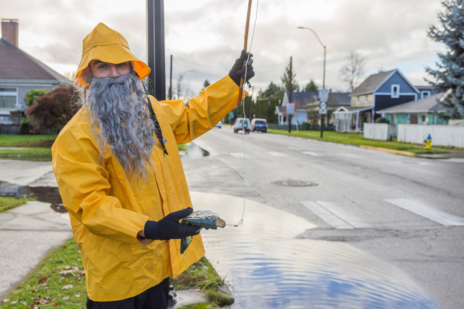 Henry Wegener poses fro a photo with a plastic fish on a line along South Pearl Street in Centralia as water levels begin to drop around Hub City on Thursday, Dec. 7.