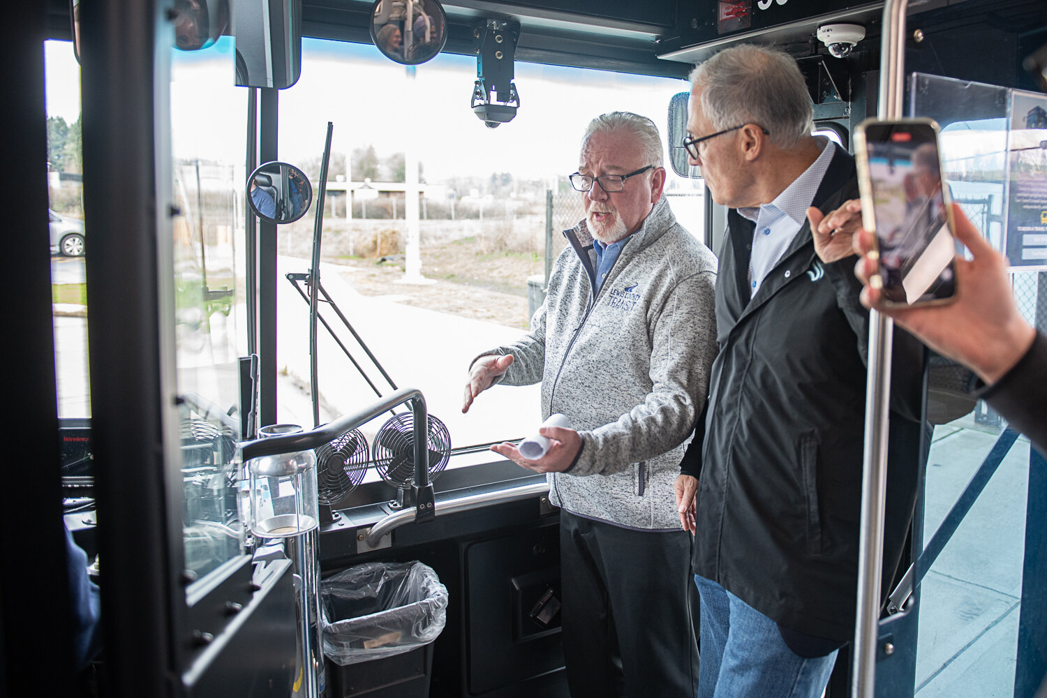 Lewis County Transit Executive Director Joe Clark, left, explains the system's process of touch charging to Gov. Jay Inslee aboard an all electric bus on Friday, Jan. 19.
