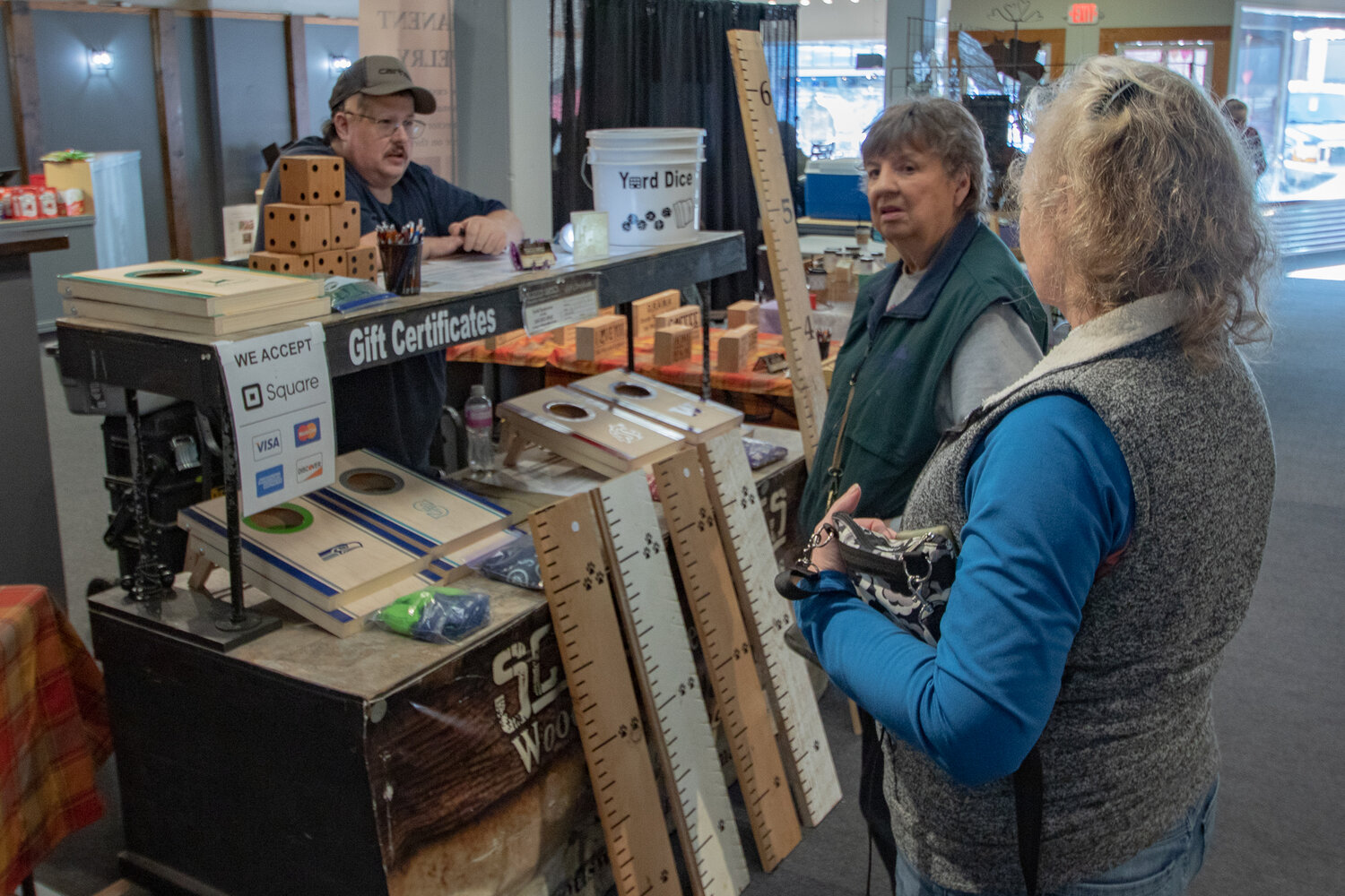 Customers talk to Scott Anderson of Scott's Games on Friday, Feb. 2, during the soft opening of the Northwest Salmon Smokehouse and Artisan Market in downtown Chehalis.